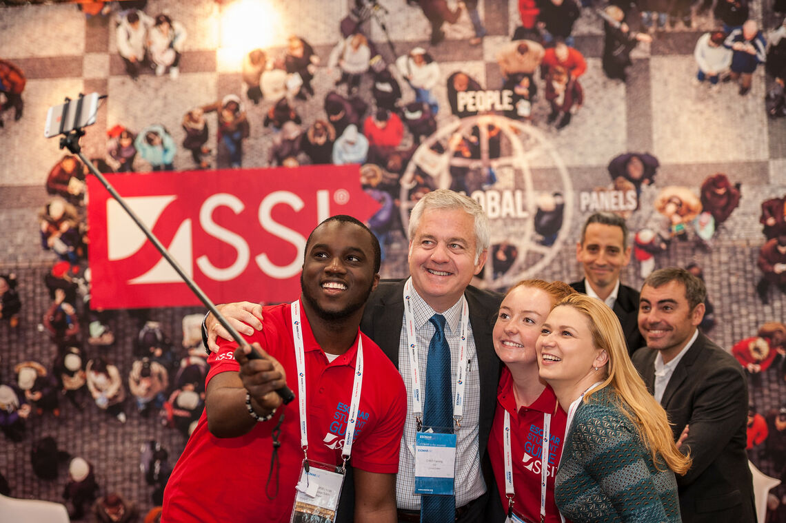 Congress attendees posing in front of a sponsored stand